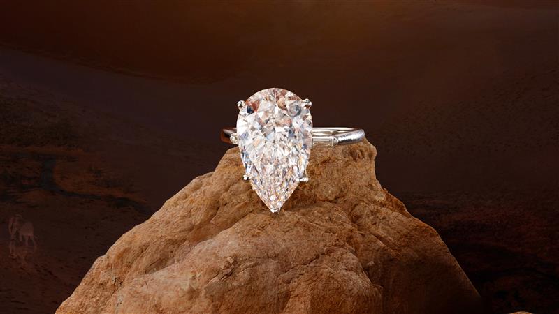A pear-shaped natural diamond ring perched on a rock