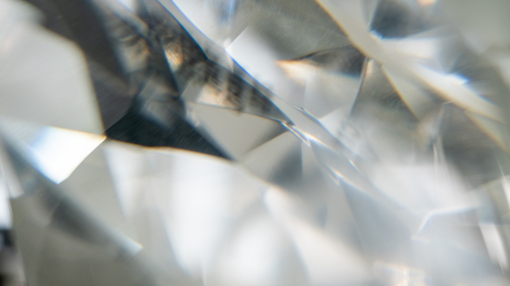 A close-up shot of a natural diamond showing it's unique facets and inclusions